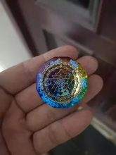 Load image into Gallery viewer, Rainbow chakra pendant with Sri Yantra. A circular pendant held in hand with chakra colors.
