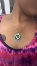 Load image into Gallery viewer, Silver tone necklace featuring a spiral design pendant with piano keys.

